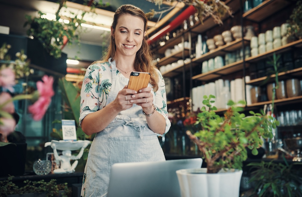 Commerçante consultant son téléphone dans sa boutique